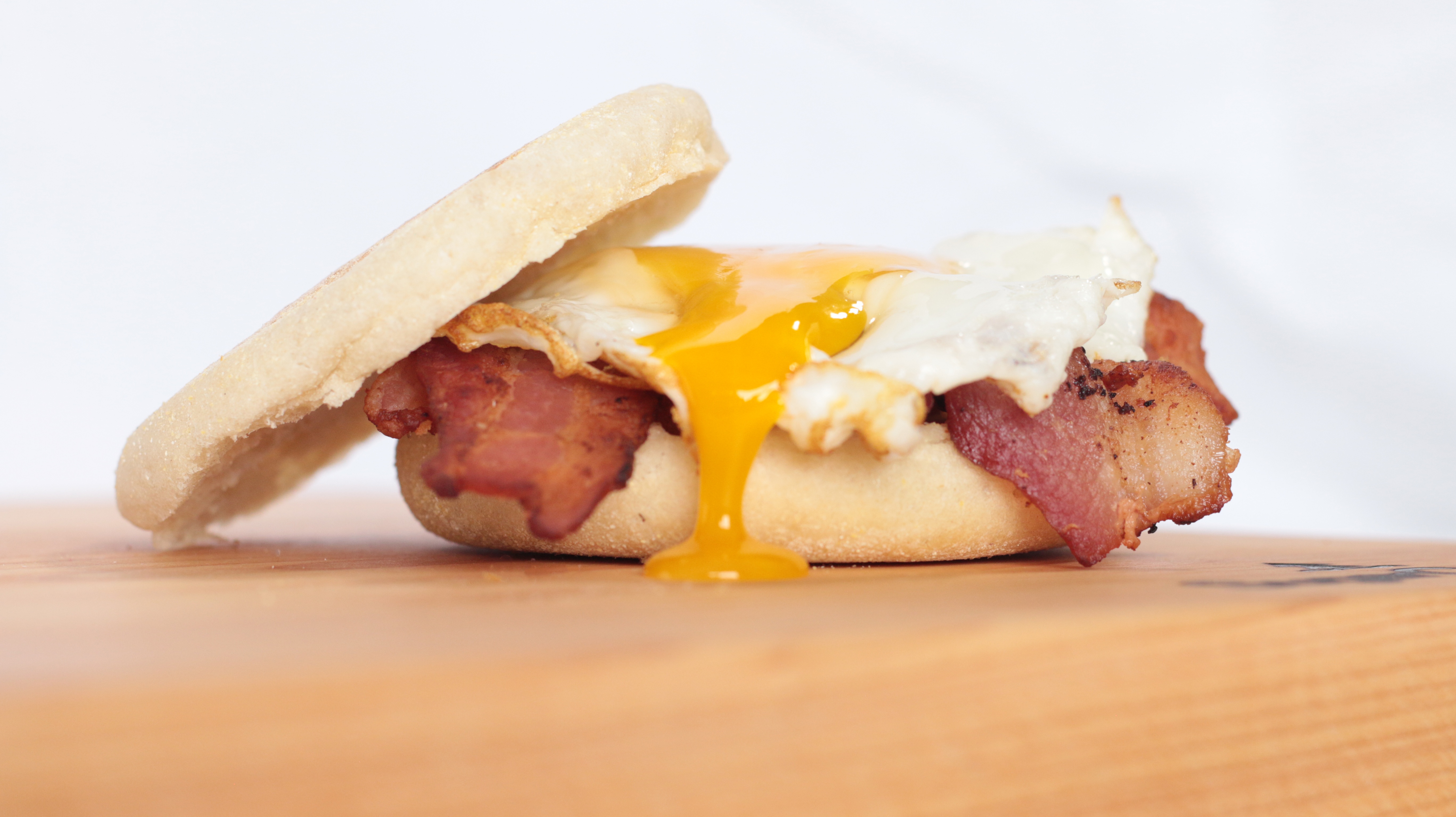 Bacon and egg sandwich on a biscuit with egg yolk running down